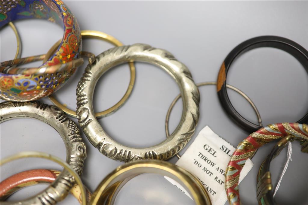 A collection of bangles, including five ethnic white metal examples,